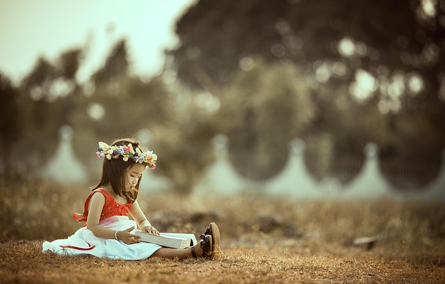 Young child sitting beside a calm cat reading a picture book together in a cozy room